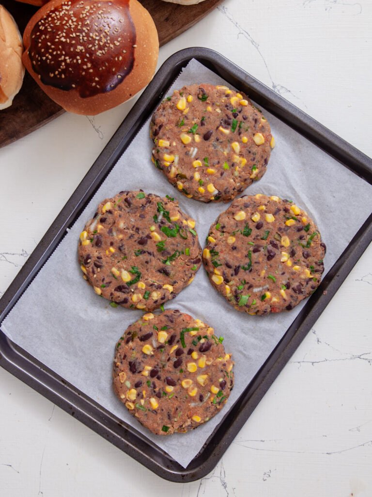 uncooked patties shaped and arranged on a baking tray