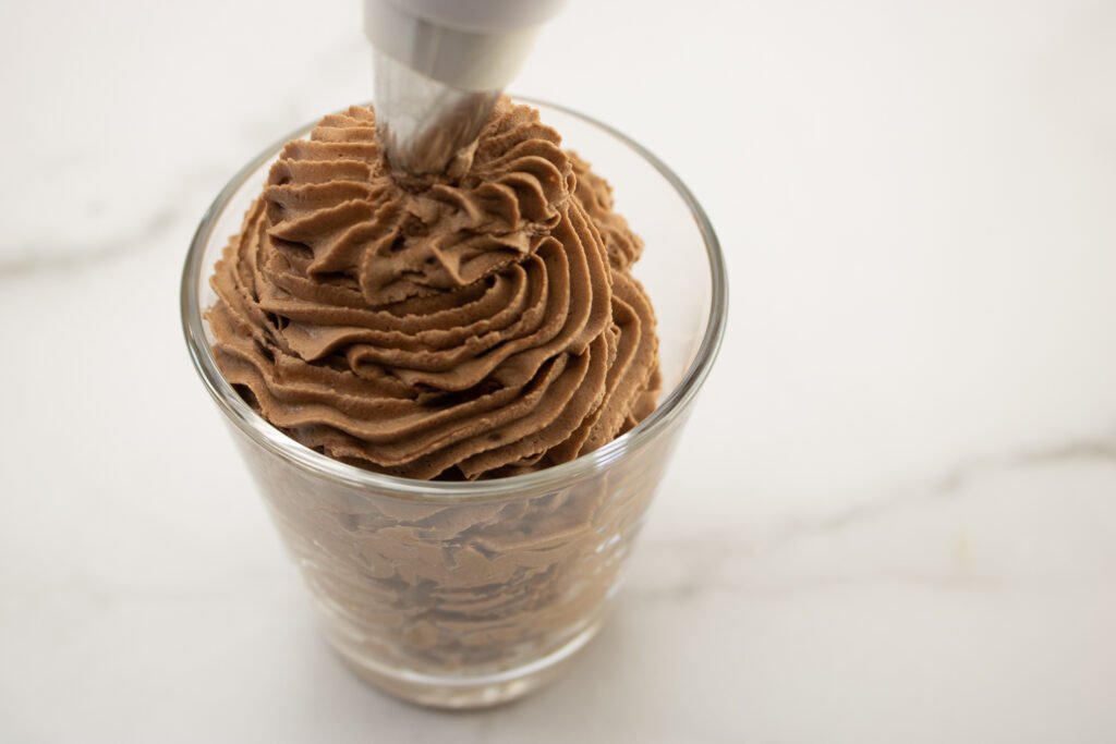 spoon the chocolate mousse into a piping bag and pipe it into small dessert cups