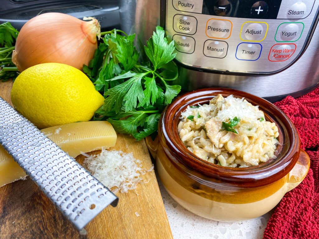 Instant Pot lemon parsley chicken risotto served in a brown bowl with fresh ingredients and a grater on the side