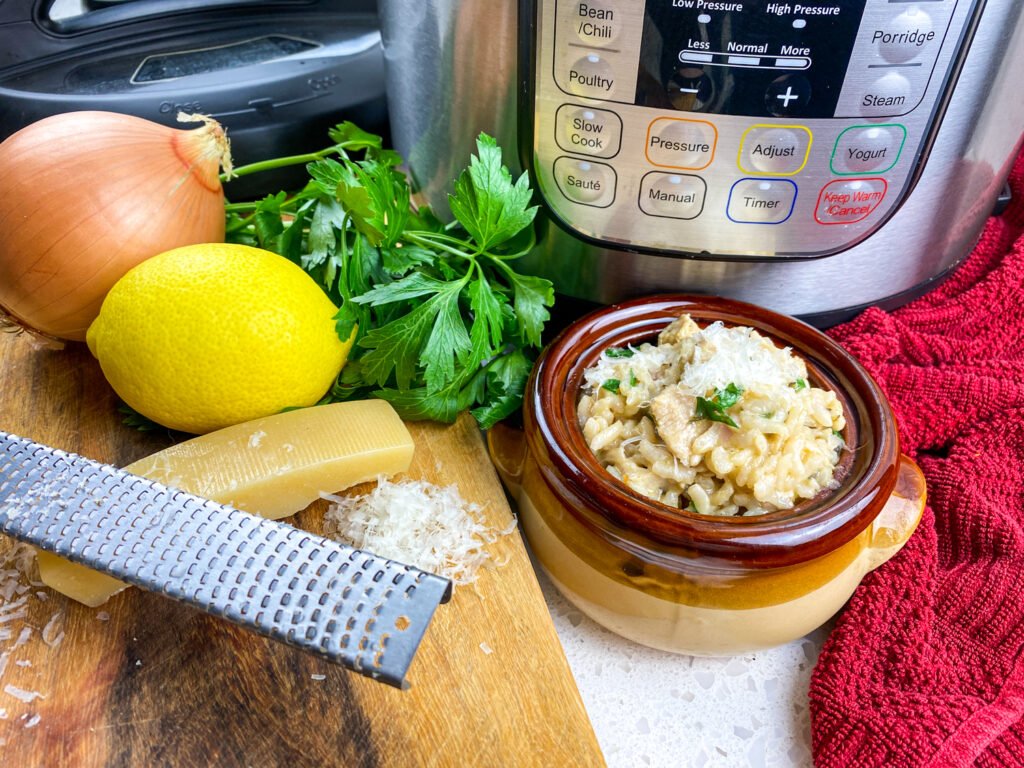 Instant Pot lemon parsley chicken risotto served in a brown bowl with fresh ingredients and a grater on the side
