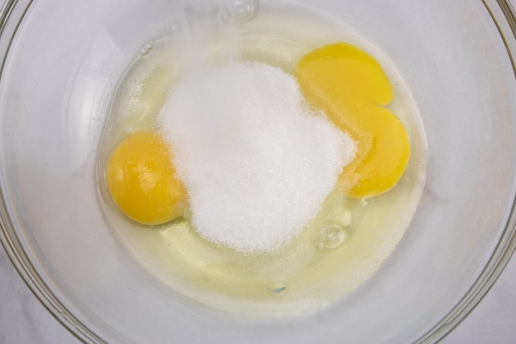 mixing sugar and eggs in a bowl to make chocolate mousse