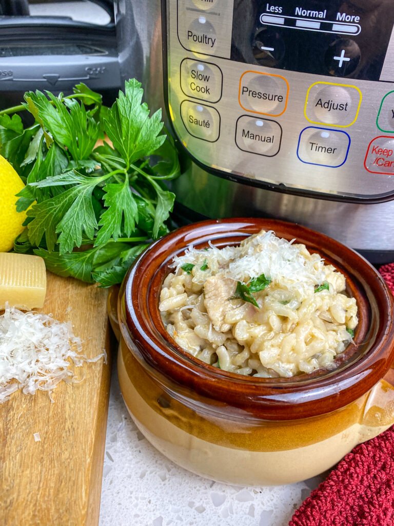 Instant Pot lemon parsley chicken risotto served in a brown bowl with fresh ingredients and a grater on the side