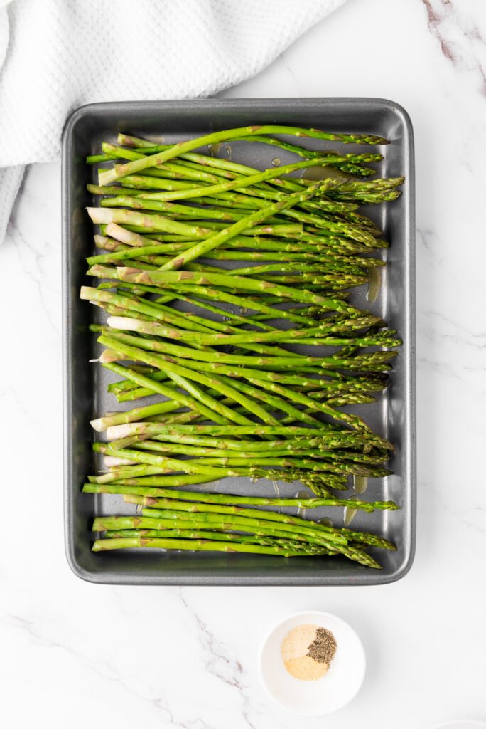 fresh asparagus on a baking tray