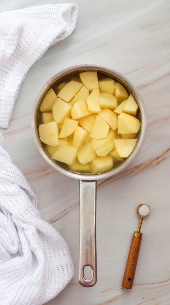 Chopped potatoes in a pot of water, ready to be boiled for potato salad