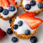 Berry granola cups filled with yogurt and topped with fresh strawberries and blueberries
