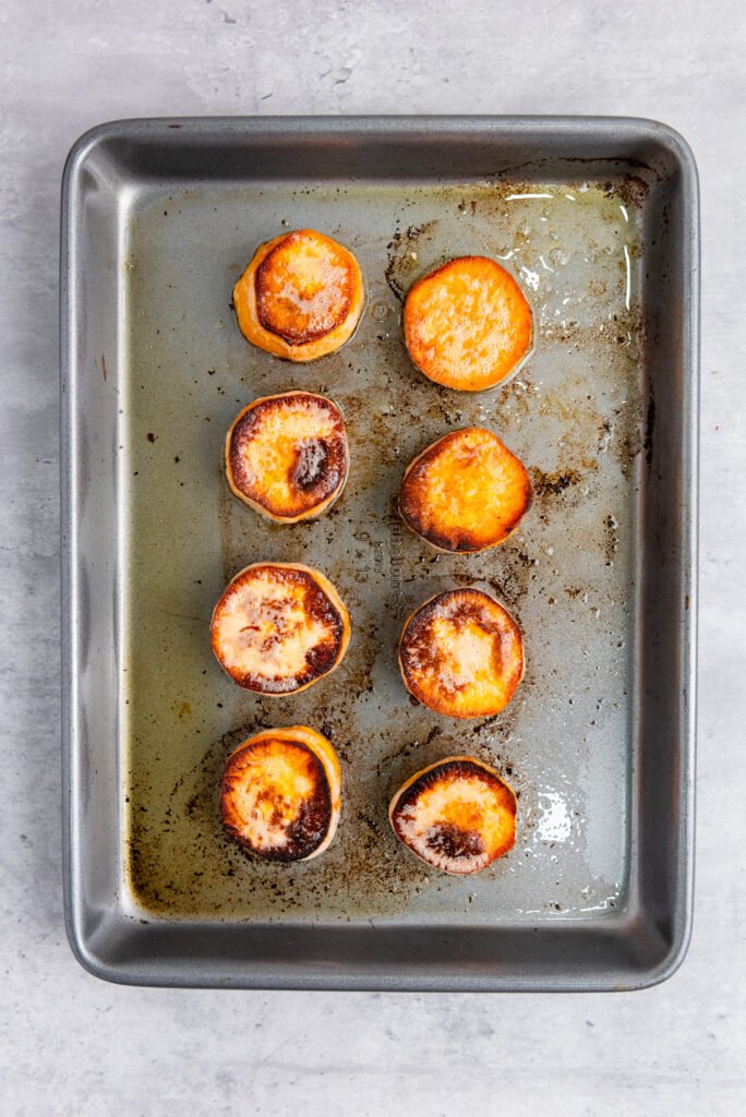 Roasted sweet potato slices on a baking tray