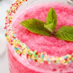 Watermelon slushie served in a sprinkle-rimmed glass with mint