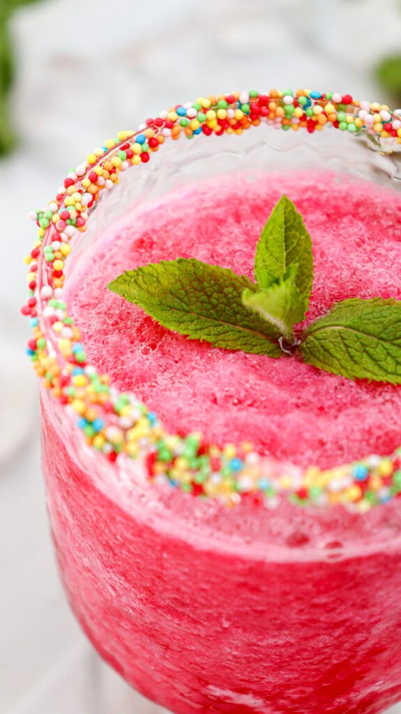 Watermelon slushie served in a sprinkle-rimmed glass with mint