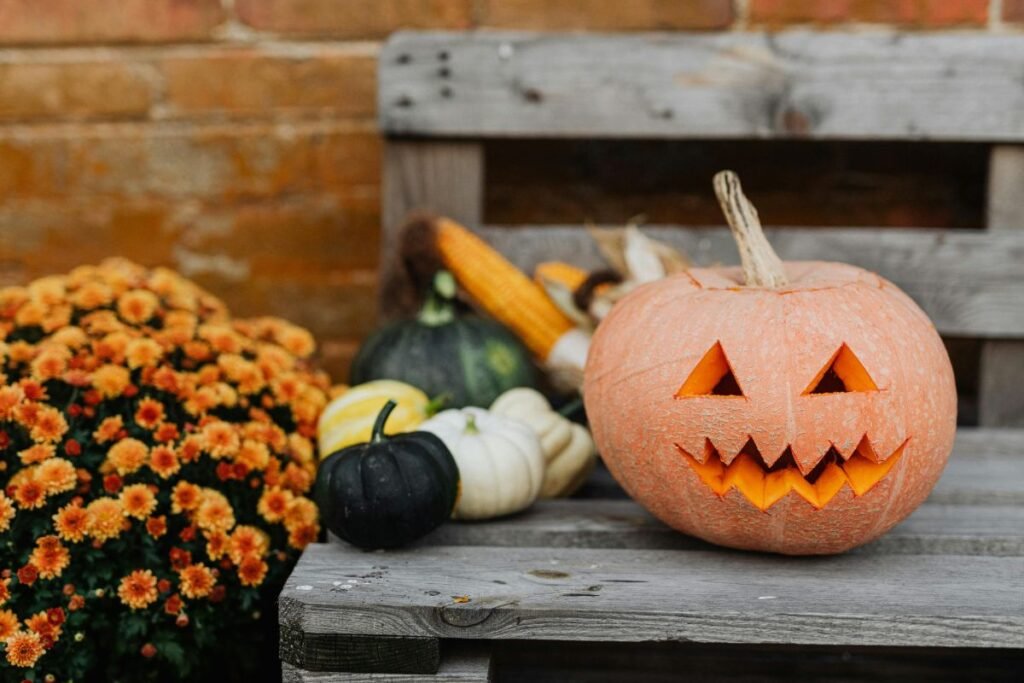 Carved jack-o’-lantern with a toothy grin on a wooden bench