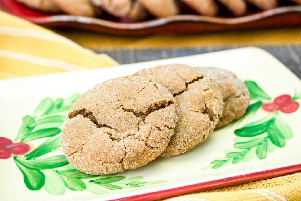 Three sugar-coated gingersnap cookies on a festive plate