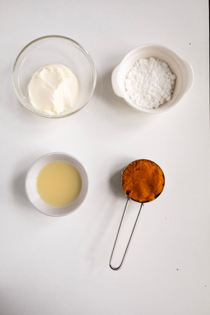 Cream cheese, powdered sugar, lemon juice, and pumpkin purée for the pumpkin cinnamon rolls frosting