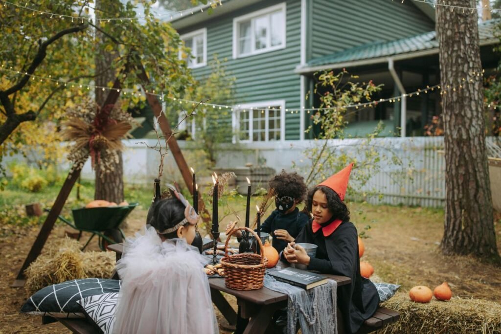 Children in Halloween costumes sitting at a decorated outdoor table