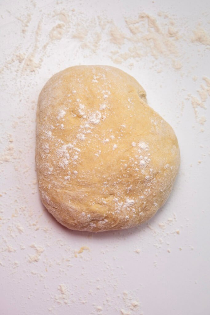 pumpkin cinnamon roll dough resting on a floured surface