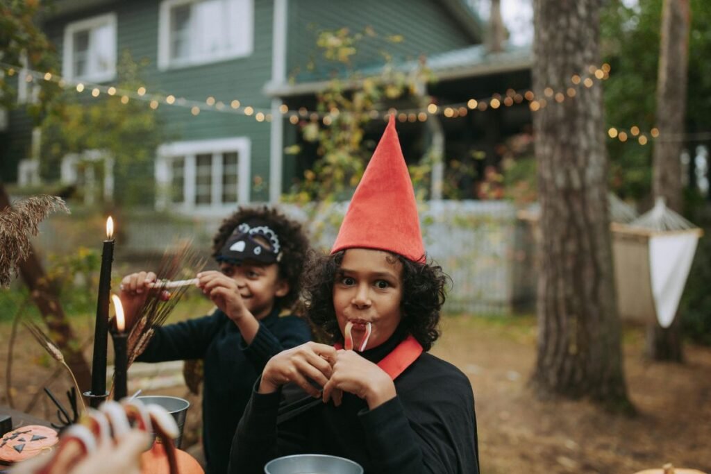 Two children in Halloween costumes enjoy treats at an outdoor party