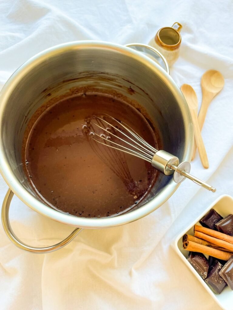 Cinnamon tequila hot chocolate being whisked in a saucepan until smooth

