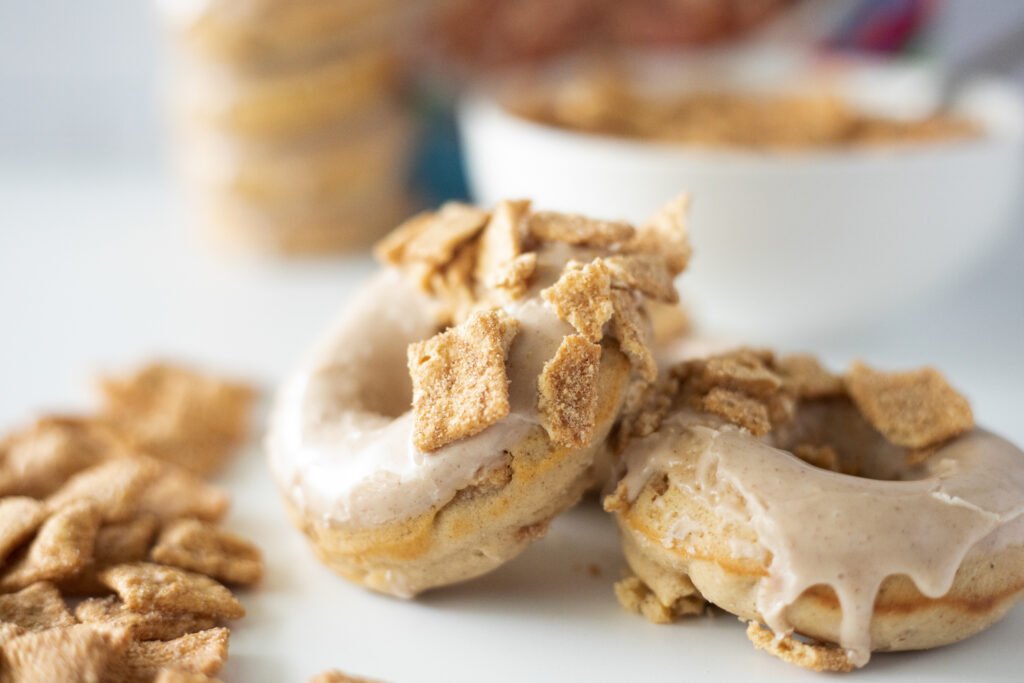 Close-up of Cinnamon Toast Crunch donuts topped with maple glaze and crushed cereal pieces