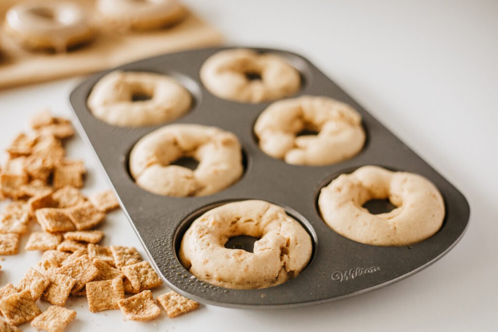 Freshly baked Cinnamon Toast Crunch Donuts cooling in a nonstick donut pan