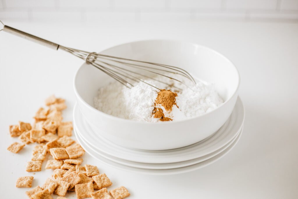 White mixing bowl with powdered sugar and ground cinnamon