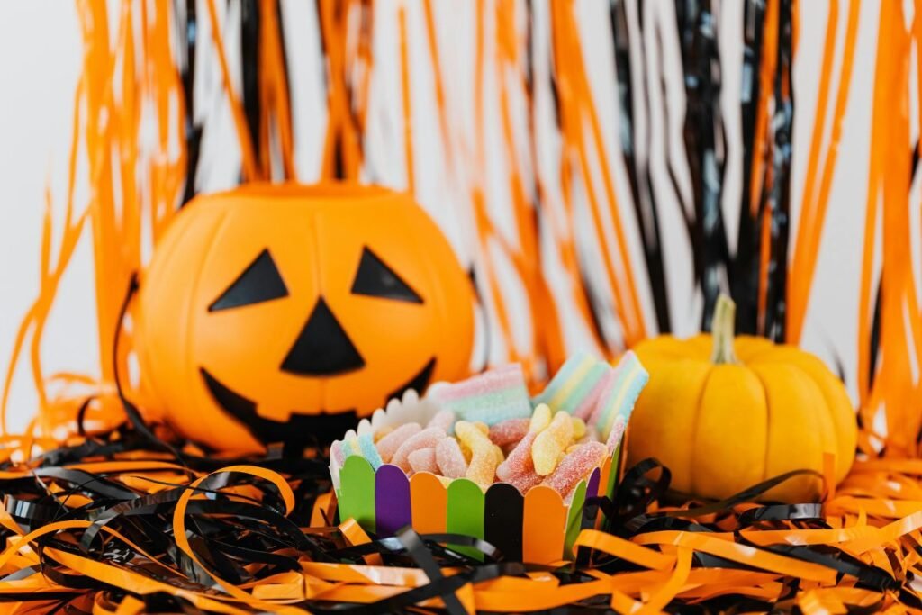 A colorful Halloween candy box filled with gummy treats sits on orange and black streamers